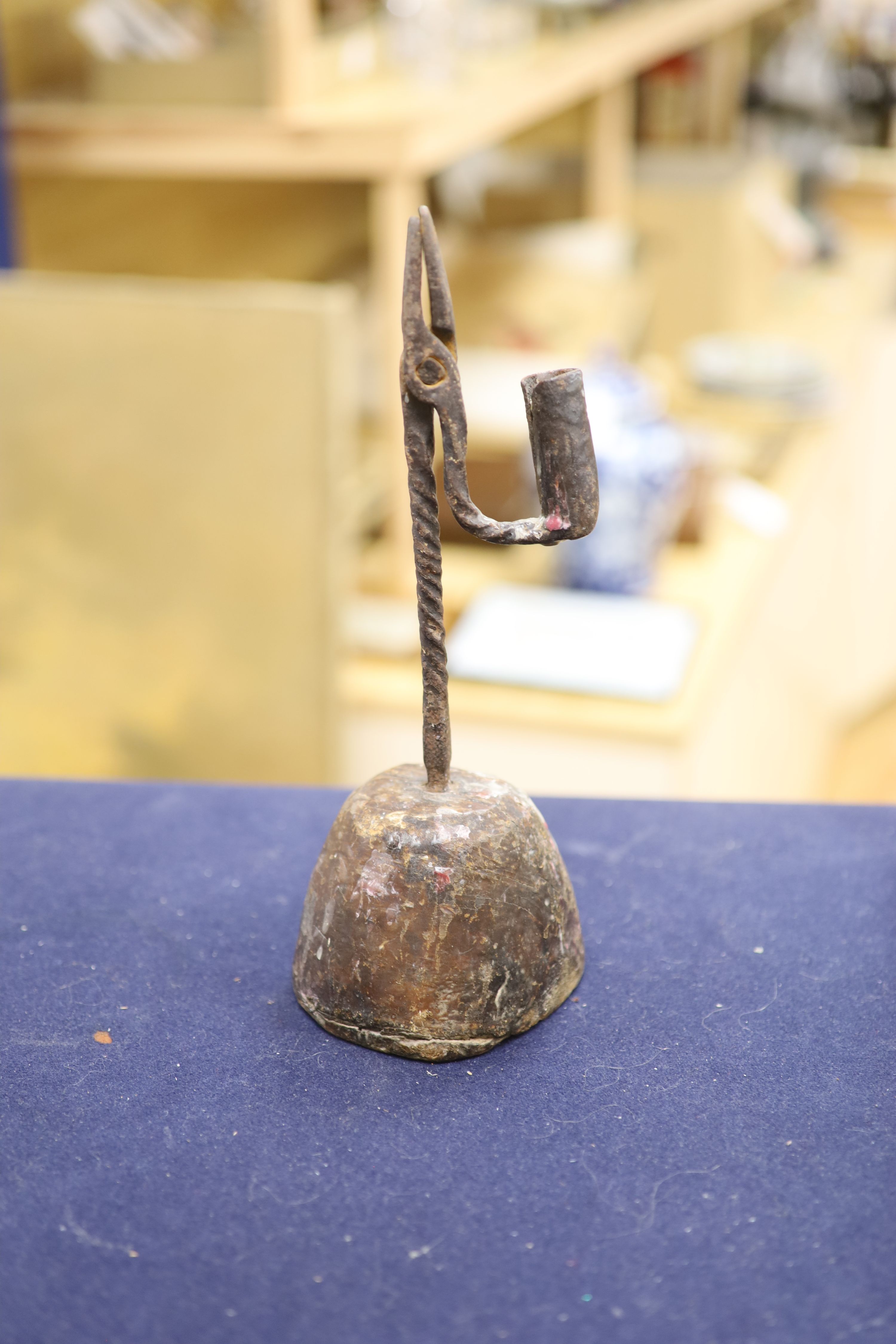 A pair of Regency brass ejector chambersticks (lacking snuffers) and an early 19th century wrought iron rushlight holder